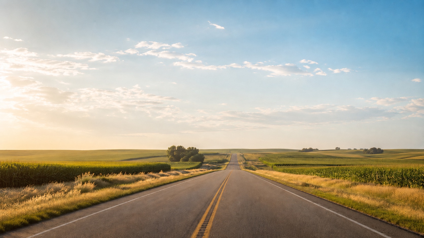 Nebraska road leading through farmland toward grain silos
